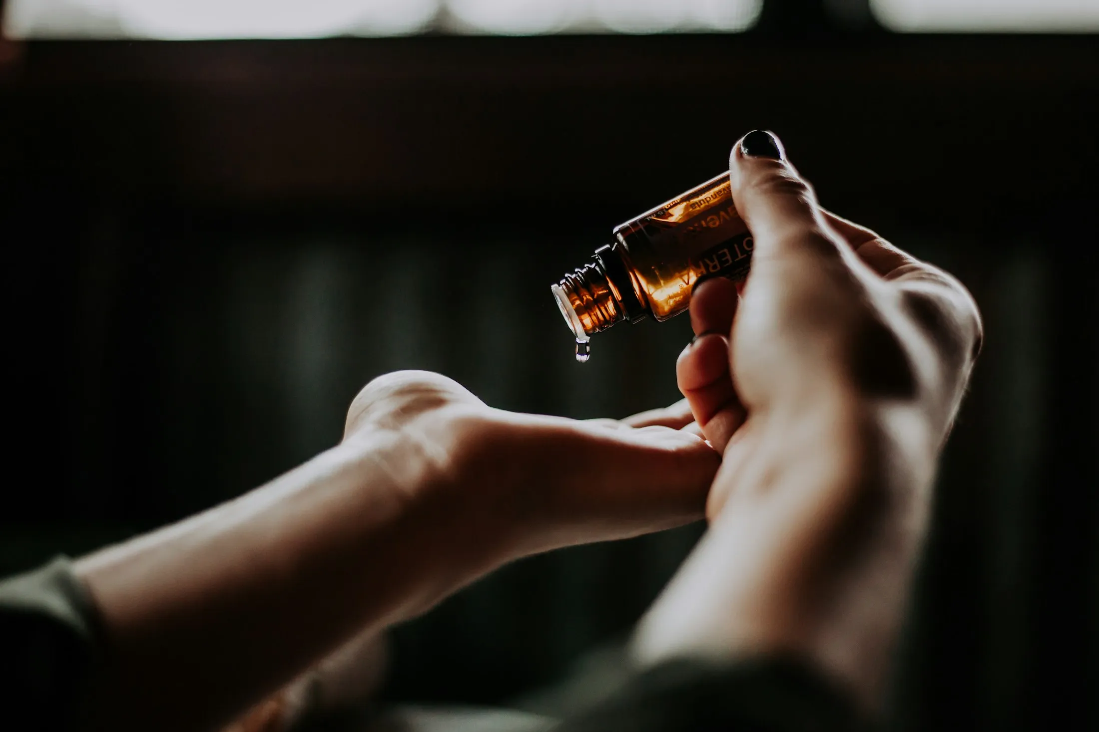 Aceite esencial doTERRA cayendo durante un masaje con aromaterapia